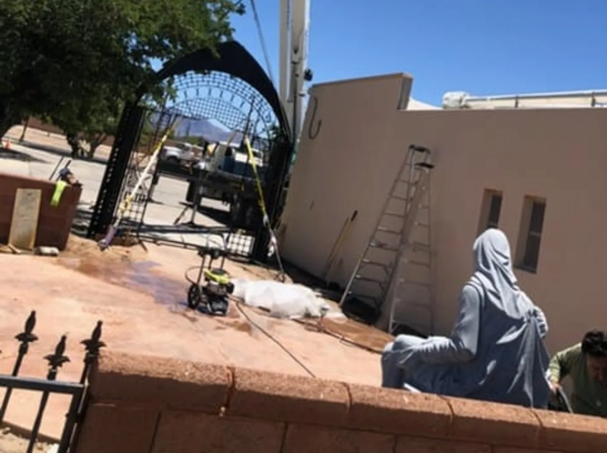 Welder setting a large steel structure on-site with a crane in Las Cruces