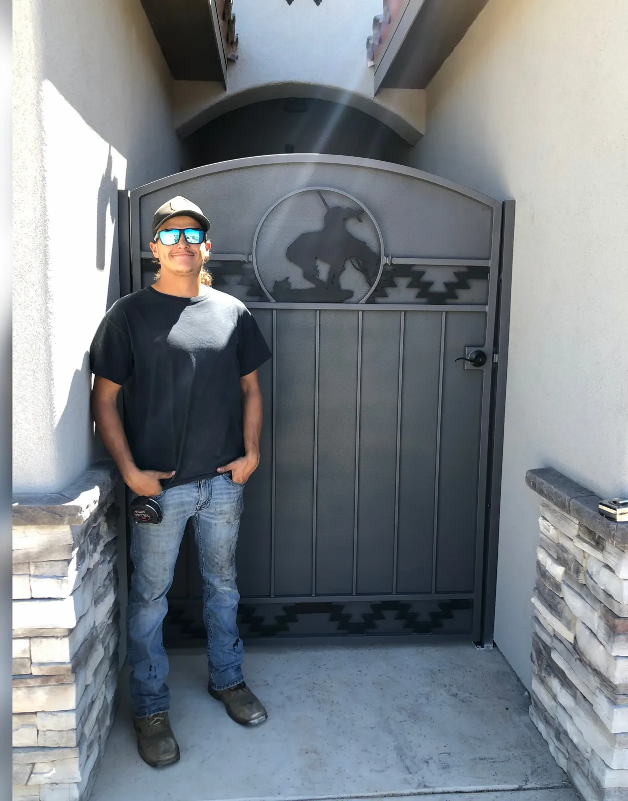 Charcoal steel courtyard gate with a cowboy-and-horse cutout and Southwest border