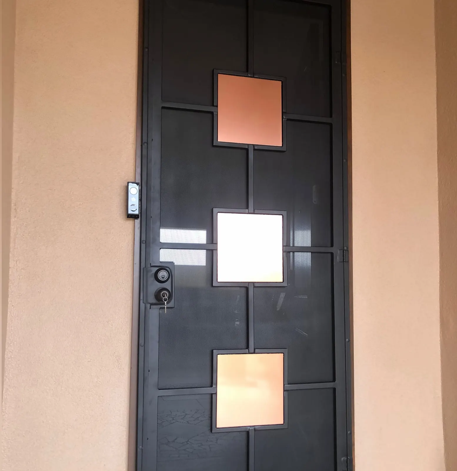 Modern black security door with copper and white square panels, Las Cruces