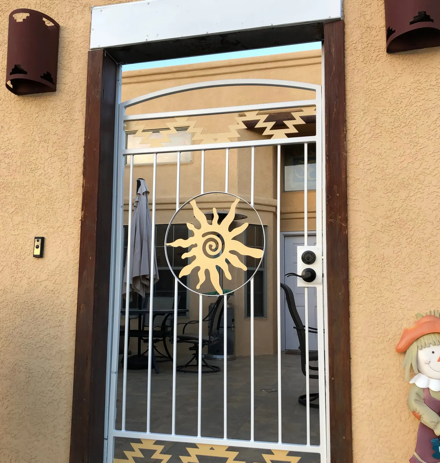 Custom Southwest courtyard entry gate with a sun medallion and step-pattern panels