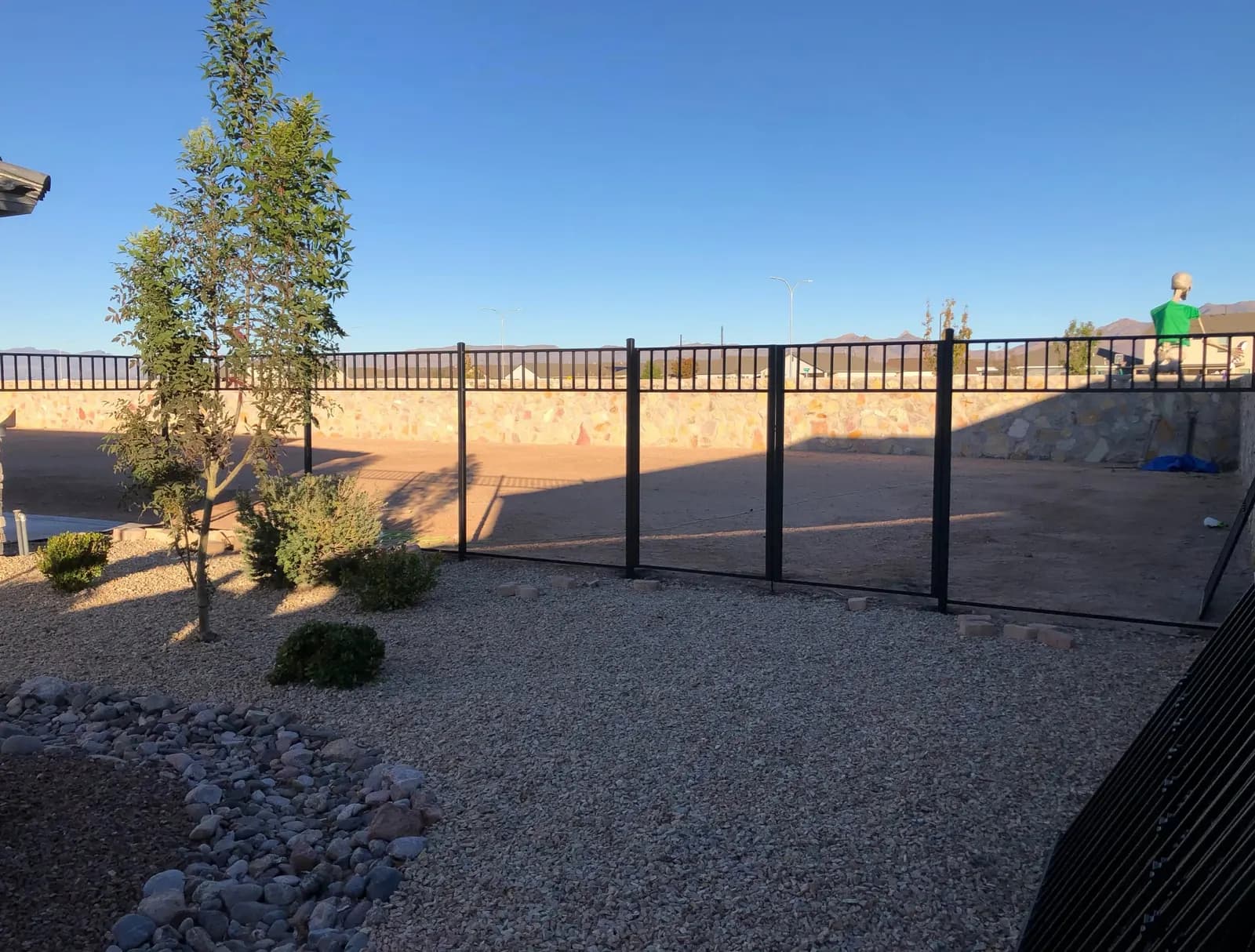 Black steel view fence around a desert-landscaped backyard